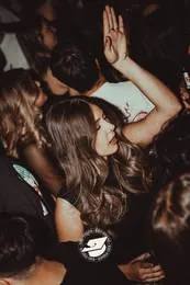 Ragazza tra la folla con le mani alzate