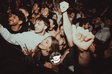 La folla che canta con le braccia alzate